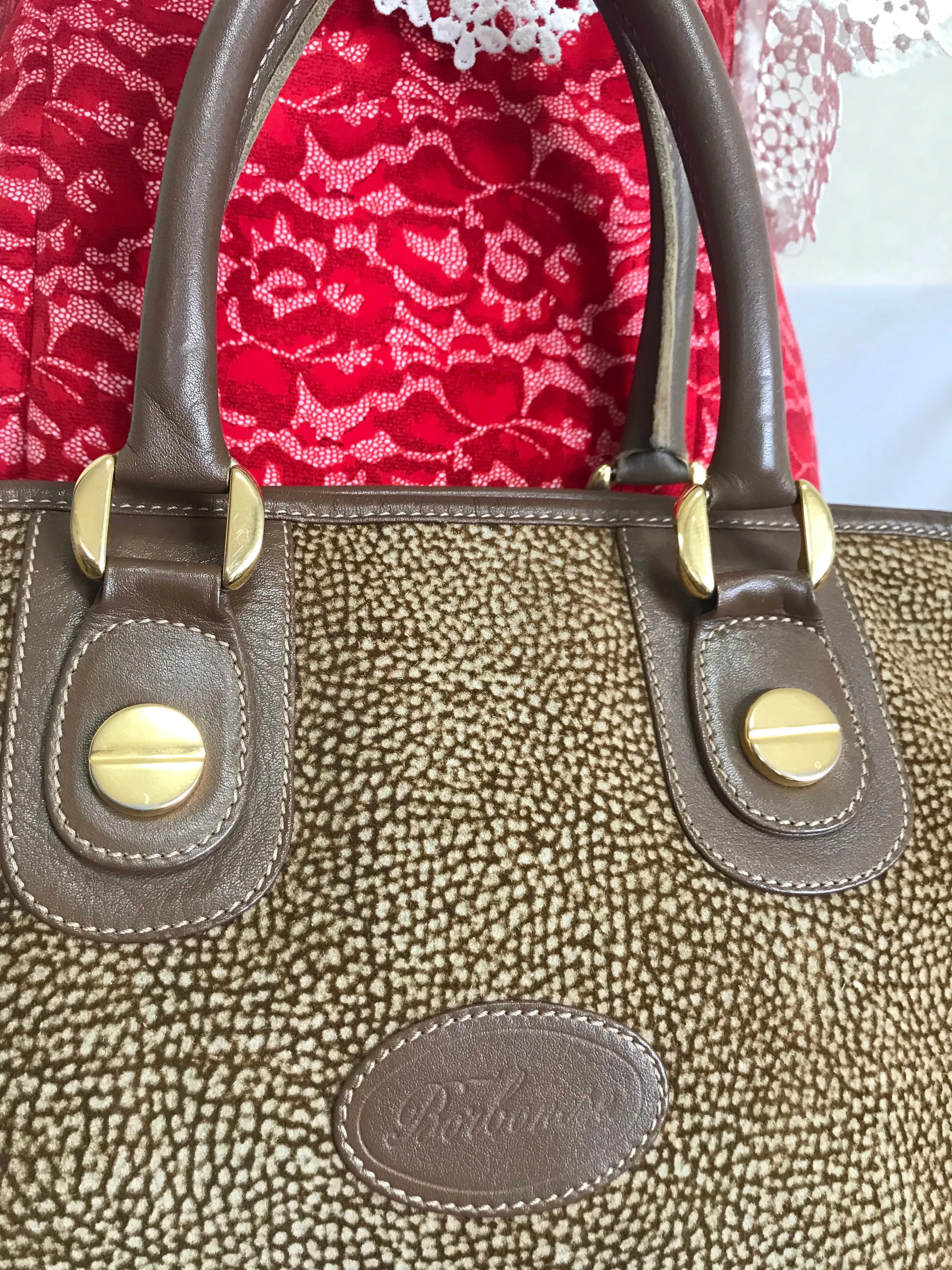 Vintage Borbonese by red wall, brown and beige leather classic bag with golden logo charm.  Unisex use. Masterpiece.